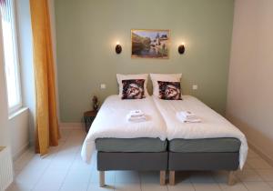 a bedroom with a bed with two towels on it at Hotel Rêve de la Vallée in Blesle