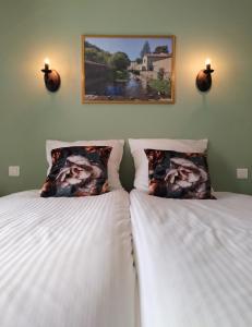dos camas sentadas una al lado de la otra en un dormitorio en Hotel Rêve de la Vallée en Blesle