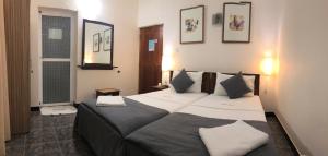 1 dormitorio con 1 cama grande y 2 almohadas en West Dene, en Negombo