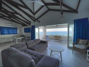 a living room with a couch and a table at VallonEnd Beachfront villa with excellent view in Bel Ombre