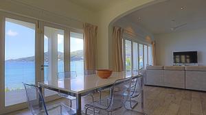 jadalnia ze stołem i krzesłami oraz oceanem w obiekcie VallonEnd Beachfront villa with excellent view w mieście Bel Ombre