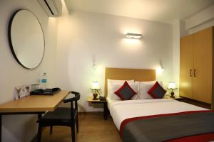 a bedroom with a bed and a desk and a mirror at BK Studio And Rooms Near Huda City Centre in Gurgaon