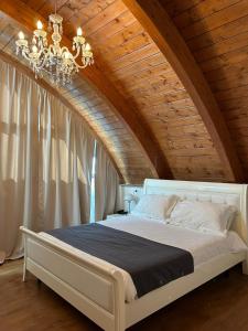 a bedroom with a large bed with a chandelier at Hotel Noventa in Noventa Vicentina