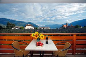 una mesa con un jarrón de flores y una botella de vino en Schattmair Hof en Tirolo