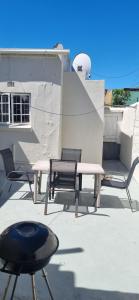 a patio with a bench and a table and chairs at HOME AWAY FROM HOME in Cape Town
