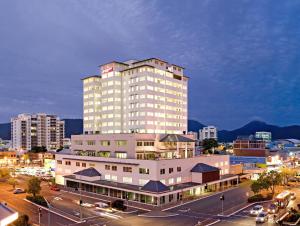 a large white building in a city with a parking lot at Cairns Central Plaza Apartment Hotel Official in Cairns
