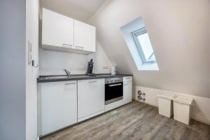 eine Küche mit weißen Schränken und einem Fenster in der Unterkunft Appartment Malerviertel in Braunschweig