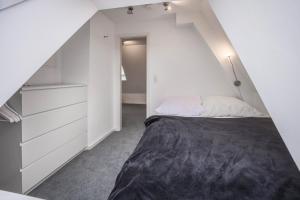 ein weißes Schlafzimmer mit einem Bett und einem Schrank in der Unterkunft Appartment Malerviertel in Braunschweig