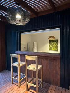 two chairs sitting at a bar with a mirror at Cabañas en medio del bosque in Chascomús