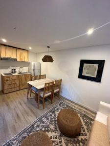 a living room with a table and a kitchen at Cabañas en medio del bosque in Chascomús +18 photos