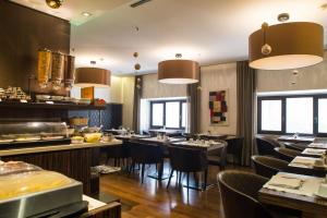 Divina Luxury Hotel في روما: مطعم بطاولات وكراسي ونوافذ