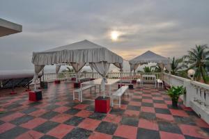 een resort met tafels en stoelen op een geruite vloer bij Hotel Salty Waves Baga in Baga