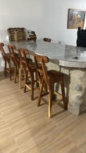 a large stone table with wooden chairs around it at Finca La Esperanza Pereira in Pereira