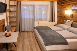 a bedroom with a bed and a table and a window at Pension Kreischberg Mayer in Sankt Lorenzen ob Murau