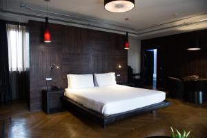 Divina Luxury Hotel في روما: غرفة نوم مع سرير أبيض كبير في غرفة