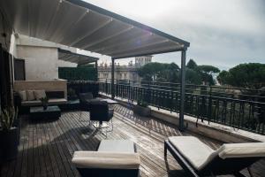 Divina Luxury Hotel في روما: شرفة مع كراسي وطاولات على مبنى