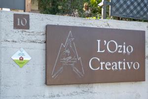 a sign on a wall that says laoco creative at Chalet l'ozio creativo in Castelnuovo Nigra