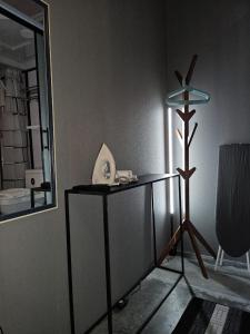 een kamer met een tafel met een spiegel en een lamp bij Le Melur in George Town