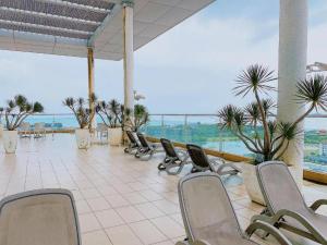 a row of chairs in a room with the ocean at Comfy King The Straits Suite 715 by Elefen Homestay in Melaka