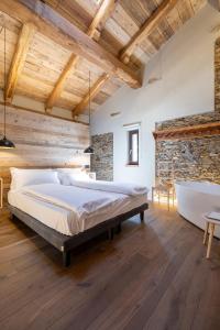 a bedroom with a large bed and a bathtub at Chalet l'ozio creativo in Castelnuovo Nigra