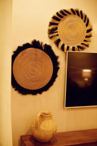 a wall with three plates and a vase on a table at 8TWENTY8 Residence in Kigali