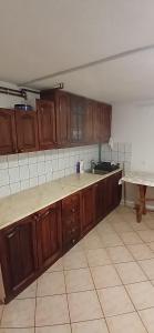 an empty kitchen with wooden cabinets and a table at Samostanska kuća in Fojnica