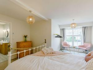 a bedroom with a bed and a desk and a window at 4 Bed in Chulmleigh 85596 in Chulmleigh