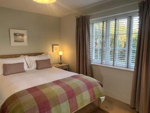 a bedroom with a bed and a large window at Cobblers Lodge in Lyme Regis