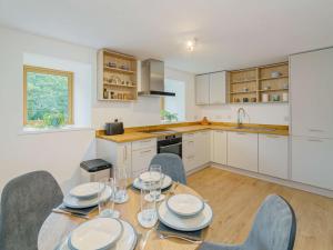 a kitchen with a wooden table with chairs and a dining room at 2 Bed in Aberystwyth 83552 in Llanilar