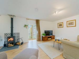 a living room with a fireplace and a couch at 2 Bed in Aberystwyth 83552 in Llanilar
