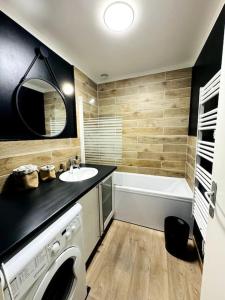a bathroom with a sink and a washing machine at Maison rénovée et chaleureuse proche du mémorial in Caen +24 photos