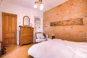 a bedroom with a brick wall and a bed at Plateau Mt-R à 2 pas des métros Laurier & Rosemont in Montreal