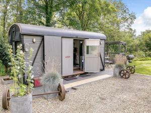 a grey caravan with wheels parked in a garden at 1 Bed in Harrogate 81300 in Hampsthwaite