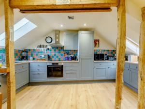 una cucina con armadi blu e pavimenti in legno di 3 Bed in Braunton 86704 a Braunton