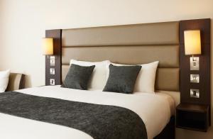 a bedroom with a large bed with two pillows at The Quays by Greene King Inns in Northampton