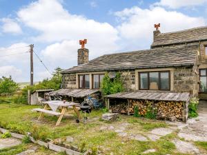 an old stone house with a picnic table in front of it at 3 Bed in Todmorden 82953 in Todmorden