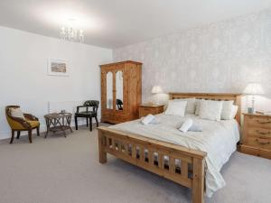 een slaapkamer met een groot bed met een houten frame bij 3 Bed in Pembroke 83322 in Pembroke