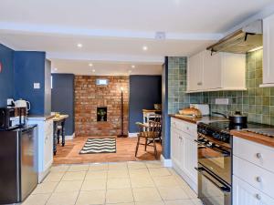 a kitchen with white cabinets and a brick wall at 3 Bed in Skegness 83461 in Wainfleet All Saints