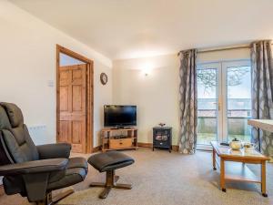 uma sala de estar com uma cadeira e uma televisão em 1 bed in Dearham SZ069 em Dearham