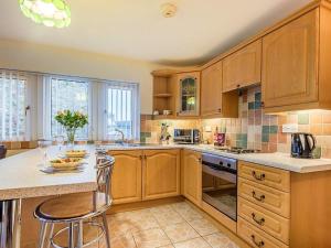 a kitchen with wooden cabinets and a island with a table at 1 bed in Dearham SZ069 in Dearham