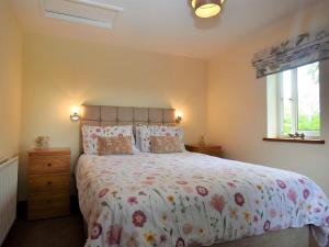 1 dormitorio con 1 cama con colcha de flores en 1 bed in Dearham SZ069, en Dearham