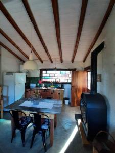 a kitchen with a table and a stove at VILLA ESPINA CHALET DE MONTAÑA a 8 km de San Javier in Villa de Las Rosas
