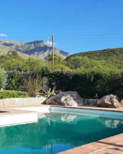 a swimming pool with blue water and mountains in the background at VILLA ESPINA CHALET DE MONTAÑA a 8 km de San Javier in Villa de Las Rosas
