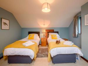 two beds in a room with yellow and blue walls at 3 bed in Milford Haven 86881 in Milford Haven
