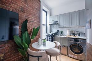 紐約的住宿－153-1G Newly Renovated 2BR Lower East Side，厨房配有桌子和砖墙