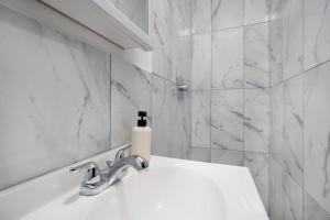 a white bathroom with a sink and a bottle of soap at 153-1G Newly Renovated 2BR Lower East Side in New York