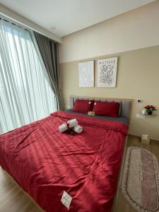 a bedroom with a red bed with two stuffed animals on it at LaLisa homestay Ecopark- Căn hộ thoải mái & ấm cúng Van giang Hung Yen in HÆ°ng YÃªn