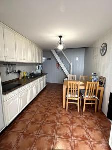 a kitchen with a table and chairs and a staircase at Kleines Haus am Meer in Arco da Calheta