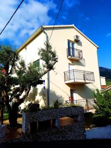 a large white building with balconies on it at Apartments Kegalj in Podstrana