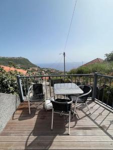 a patio with a table and chairs on a balcony at Kleines Haus am Meer in Arco da Calheta